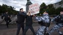 Polizeibeamte halten einen Demonstranten mit einem Plakat fest, auf dem zu lesen ist: "Freiheit für Alexej Nawalny"