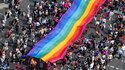 Menschen ziehen auf der 45. Berlin Pride-Parade zum Christopher Street Day (CSD) mit einer überdimensionalen Regenbogenfahne durch die Stadt. 