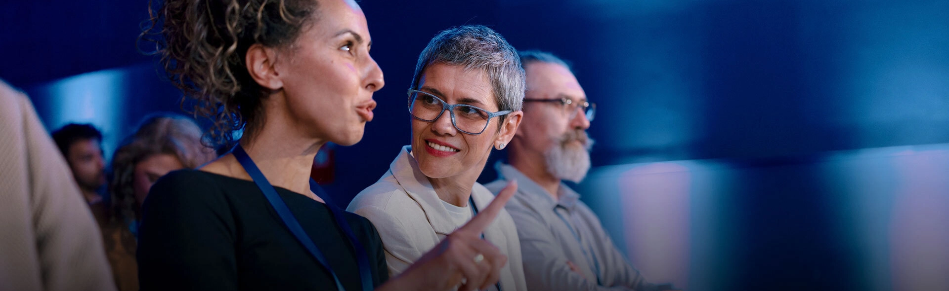 Personen unterhalten sich auf dem Podium. 