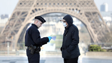 Ein Passant wird von einem Polizisten kontrolliert.