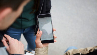 Ein Frau hält ein Smartphone in der Hand.