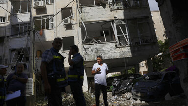 Petach Tikwa, Israel, Menschen vor den Trümmern ihres Wohnhauses, das in der Nacht von einer Rakete aus dem Gazastreifen getroffen wurde.