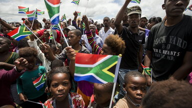 Mit Regenbogenfahnen wedelnde Unterstützer Mandelas auf dessen Beerdigung 2013