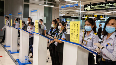 Mitarbeiterinnen warten auf Reisende am Suvarnabhumi International Airport in Bangkok