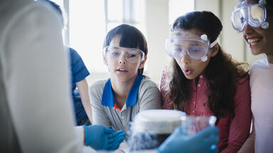 A photo of curious students looking at scientific experiment. 