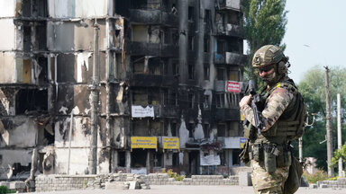 Ein Mitglied des ukrainischen Militärs steht vor beschädigten Gebäuden im Kiewer Stadtteil Borodyanka