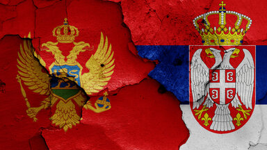Flaggen von Montenegro und Serbien auf rissige Wand gemalt