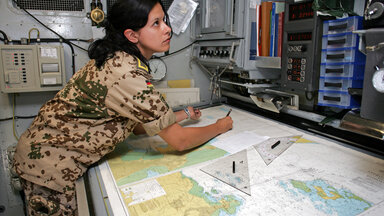 Eine Soldatin und des deutschen Marineeinsatzkontingents der Mission OPERATION ENDURING FREEDOM in Djibouti im Kartenraum der Fregatte "Luebeck"