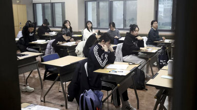 Students are waiting to take the annual university admission at a school 