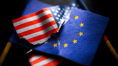 Angerissene und ineinander verkeilte EU- und USA-Fahne, Symbolfoto Zollstreit und Zoll-Deal 