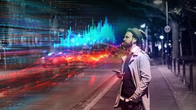 Junger Mann nutzt Smartphone mit Augmented-Reality-Datenvisualisierung auf einer Stadtstraße bei Nacht.