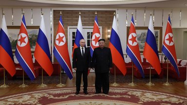 Vladimir Putin and Kim Jong Un in front of Russian and North Korean flags.