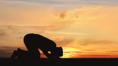 Mensch beim Gebet im Sonnenuntergang