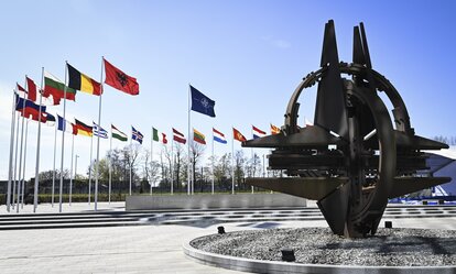 A sculpture and flags in front of the NATO headquarters in Brussels, Belgium.