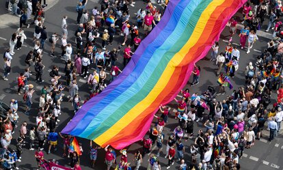 Menschen ziehen auf der 45. Berlin Pride-Parade zum Christopher Street Day (CSD) mit einer überdimensionalen Regenbogenfahne durch die Stadt.
