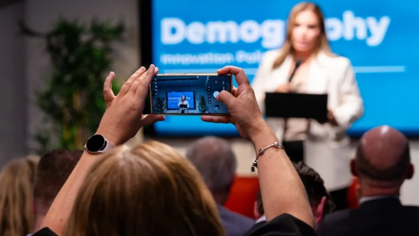 Women taking a picture of someone speaking